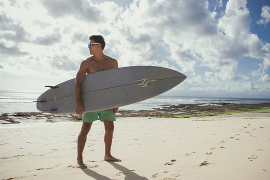 Professional Surfer Holding A Surf Board