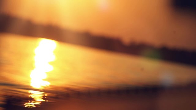 sailing into the sunset on blurred reflected water with bokeh 