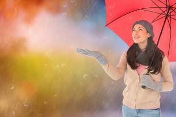 Composite image of smiling brunette feeling the rain