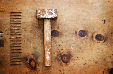 Old wood table with hammer and nails in rustic vintage style. Top view. Retro concept background.