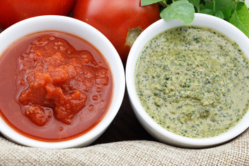 Pesto and tomato sauce with fresh basil leaves and tomatoes