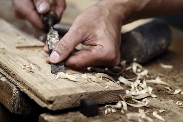 carpenter hands working with a chisel and carving tools - obrazy, fototapety, plakaty