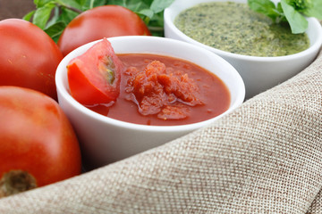 Tomato and pesto sauce with fresh basil leaves and tomatoes