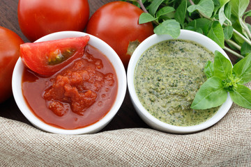 Pesto and tomato sauce with fresh basil leaves and tomatoes