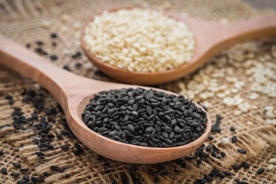 Black sesame and white sesame seed on wooden spoon