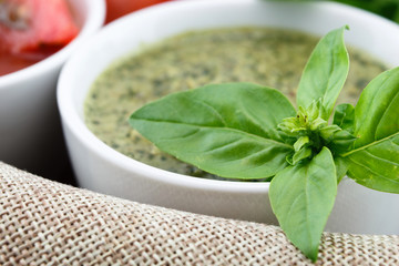 Pesto sauce and basil leaves closeup background