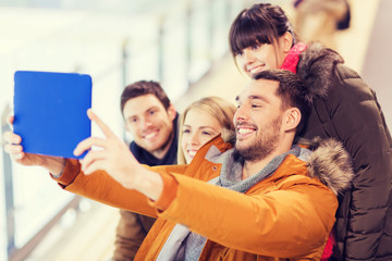 happy friends with tablet pc on skating rink