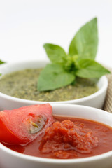 Tomato and pesto sauce with fresh basil leaves, isolated on white