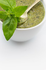 Pesto sauce and basil leaves, isolated on white background