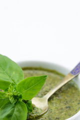 Pesto sauce and basil leaves, isolated on white background