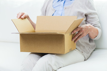 close up of senior woman with parcel box at home