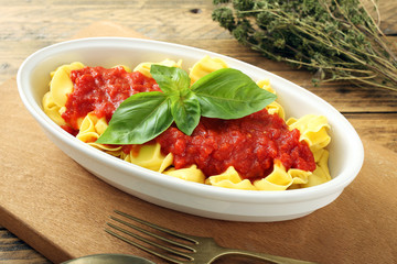 slow food tortellini pomodoro e basilico sfondo rustico