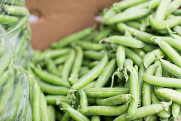 close up of green peas in box at street market