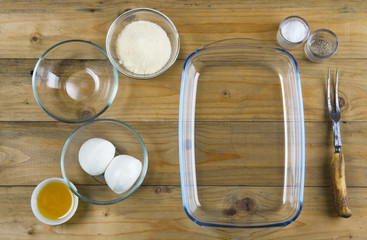 glass kitchenware on wooden background: baking tray and bowls