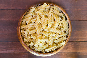 Italian pasta on wooden plate on wooden table