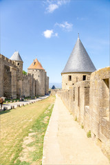 Fototapeta na wymiar Carcassonne, France. View from outside (right) on the inside of the fortress wall. Fortress of Carcassonne is included in the UNESCO World Heritage List