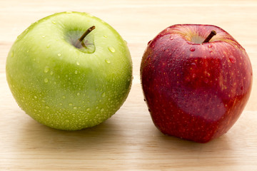 Green and red apple on wooden tsblea
