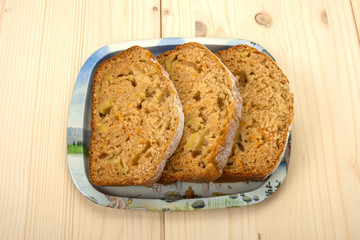 Three slices of fruitcake on a tin tray