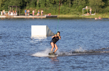 Naklejka premium Young woman study riding wakeboarding on a lake