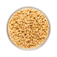 Fototapeta premium Top view of Organic Fenugreek (Trigonella foenum-graecum) in glass bowl isolated on white background