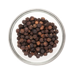 Top view of Organic Black pepper (Piper nigrum) half filled in glass bowl isolated on white background.
