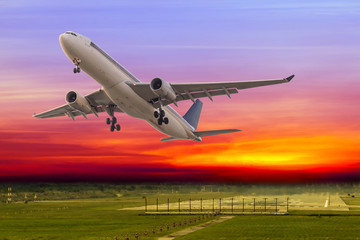 Fototapeta premium Commercial airplane take off at beautiful sunset