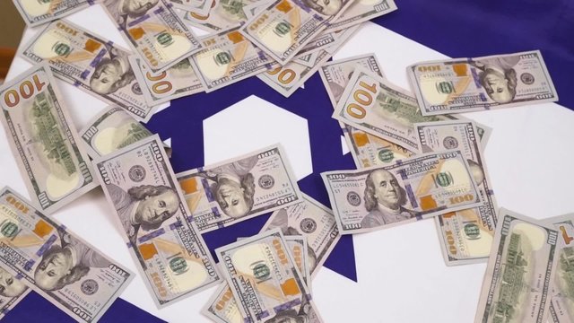 Falling hundred dollar bills on the Israeli flag