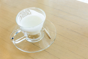 hot drink milk with spoon on wood table