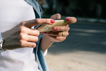 Female hand holding a cell phone outdoors