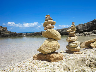 Piramide stack of zen stones near sea and blue sky