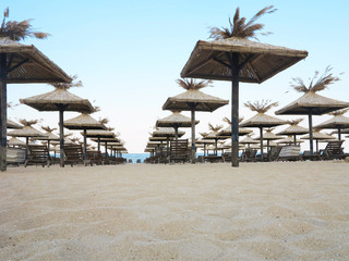 Fototapeta premium Beach chairs and umbrella on the sand near sea, blue sky