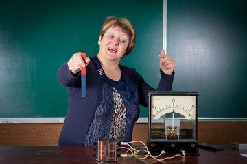 The teacher of physics explains concept of electromagnetic induction. 