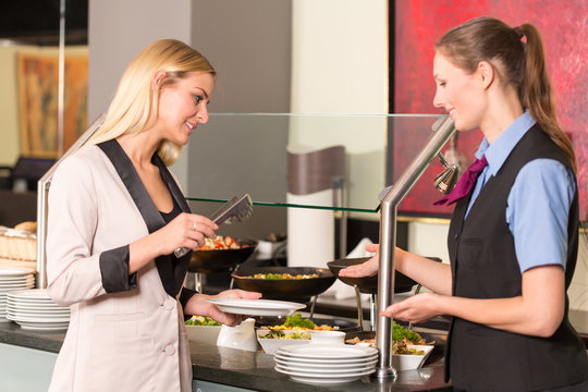 waitress consulting guest or customer in restaurant about the buffet