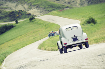 Auto d'epoca che percorre una strada a zig-zag