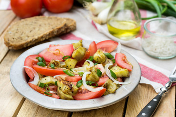 Warm autumn salad with eggplant, tomato, onion