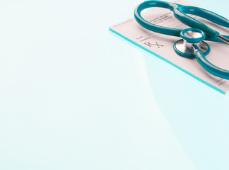 Empty medical prescription with a stethoscope on blue reflective background