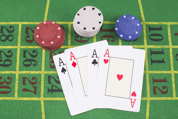 Four aces with poker rooms on green carpet