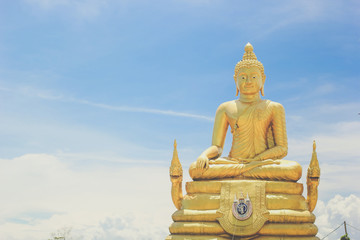 Sitting Buddha statue in Thailand over blue sky