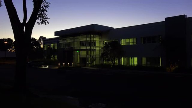 Establishing shot of the exterior of a generic modern office building at night.