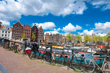 Foto op Plexiglas Amsterdam, the Netherlands-April 27: Traditional Amsterdam cityscape with medival houses, bikes on the bridge on April 27,2015. Amsterdam is the most populous city of the Kingdom of the Netherlands. © lornet