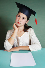  girl in graduating cap in front of sheet of paper
