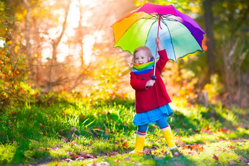 Child playing in autumn rainy park