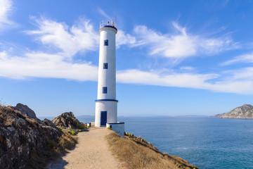 Fototapeta na wymiar Lighthouse on the ocean against a blue sky