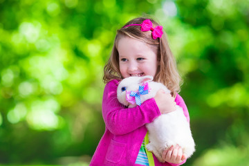 Little girl playing with rabbit