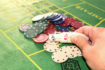 Two aces hand he caught with pieces of poker on the green carpet