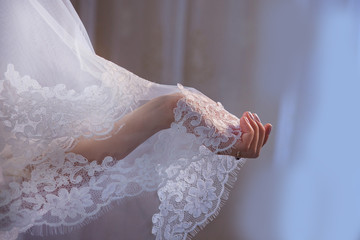 Lace veil in the hand of the bride