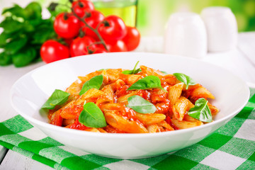 Pasta with tomato sauce and basil on table close up