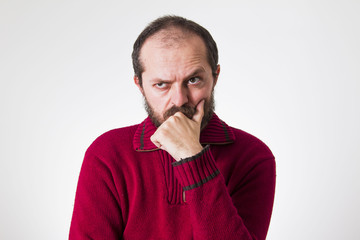 Man in red sweater, with beard and mustaches, confused and skeptic