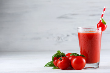 Glass of tomato juice with vegetables on wooden background