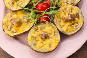 Baked potatoes with cheese and mushrooms on table close up